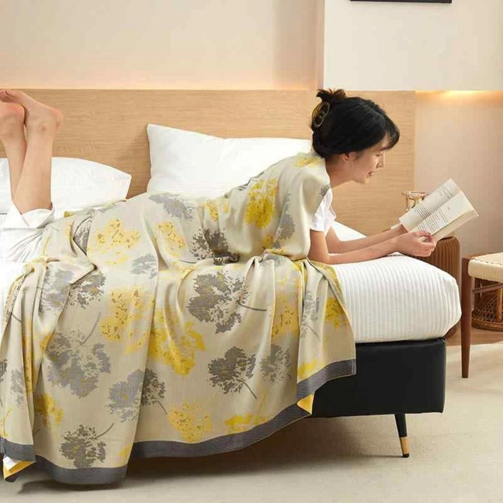A luxurious silk floral throw blanket elegantly draped over a sophisticated piece of furniture, adding a touch of elegance and comfort to the home decor setting.