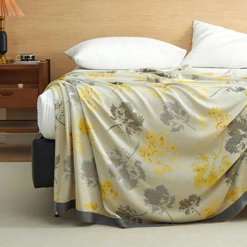 Luxurious silk floral throw blanket draped elegantly over a grey dresser, showcasing a sophisticated home decor setting.