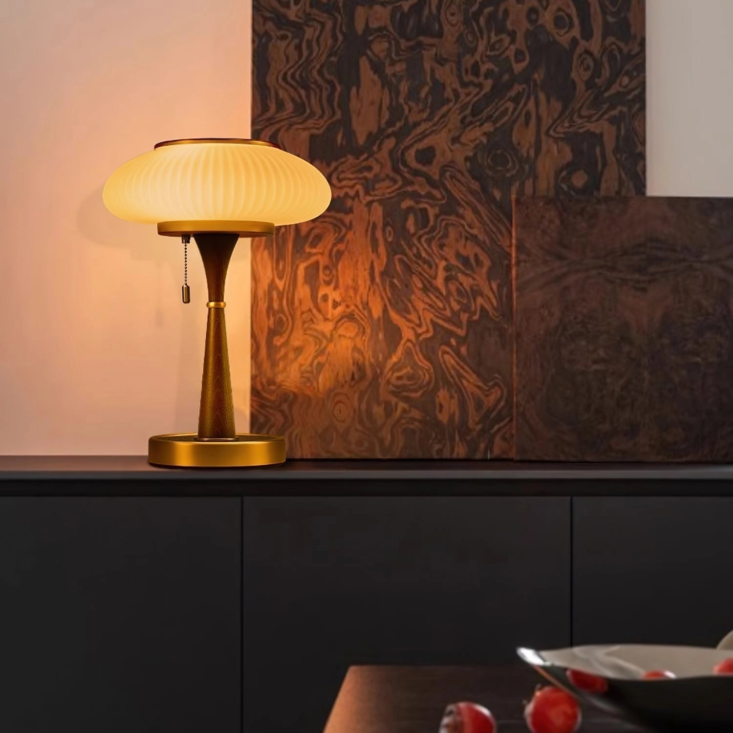 Luxury vintage table lamp with ribbed glass and gold finish placed on a wooden surface, surrounded by elegant interior decor elements.