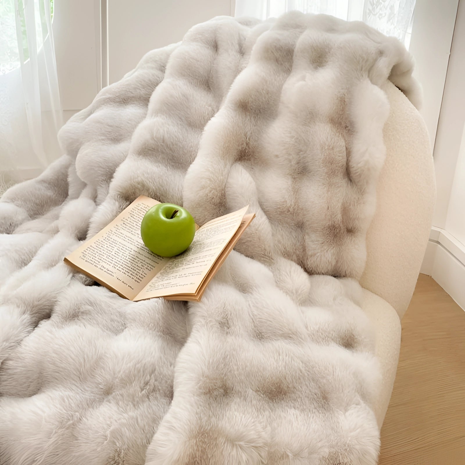 Luxury white faux fur accent chair in a cozy reading nook, featuring a plush texture with a rectangular throw pillow and soft linens, creating a comfortable and inviting atmosphere.