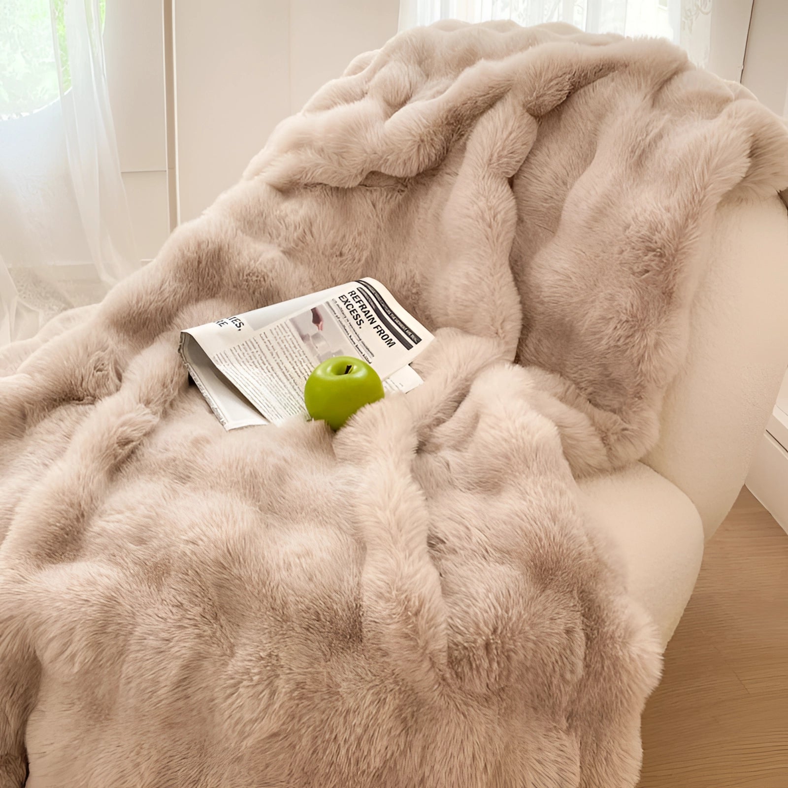 Light coffee brown luxury white faux fur accent chair in a cozy reading nook setting, showing a person's hand resting comfortably on the plush surface, highlighting the chair's comfort and texture.