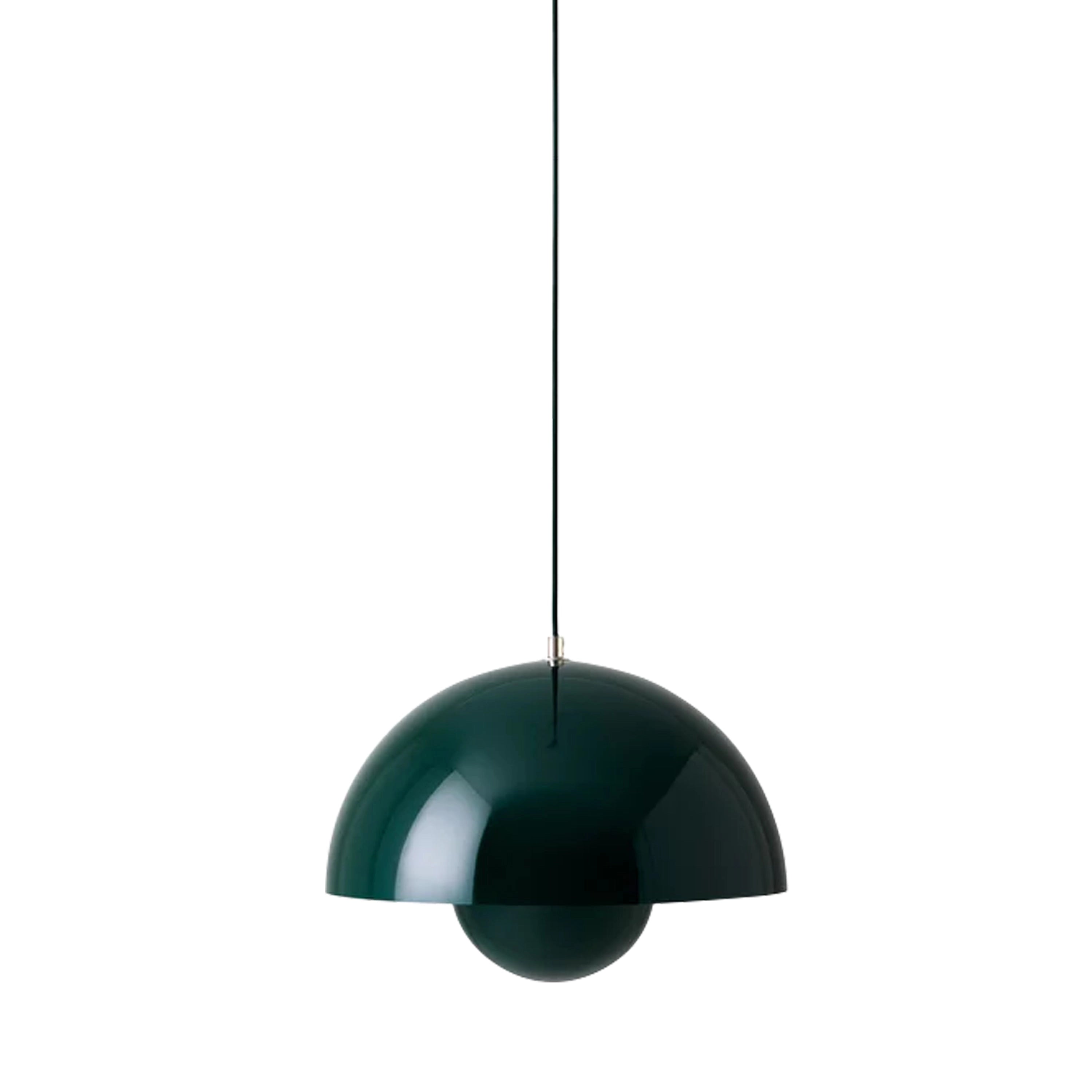 Matte black dome pendant light with a modern minimalist spherical design, featuring a green finish, hanging from the ceiling above a table.