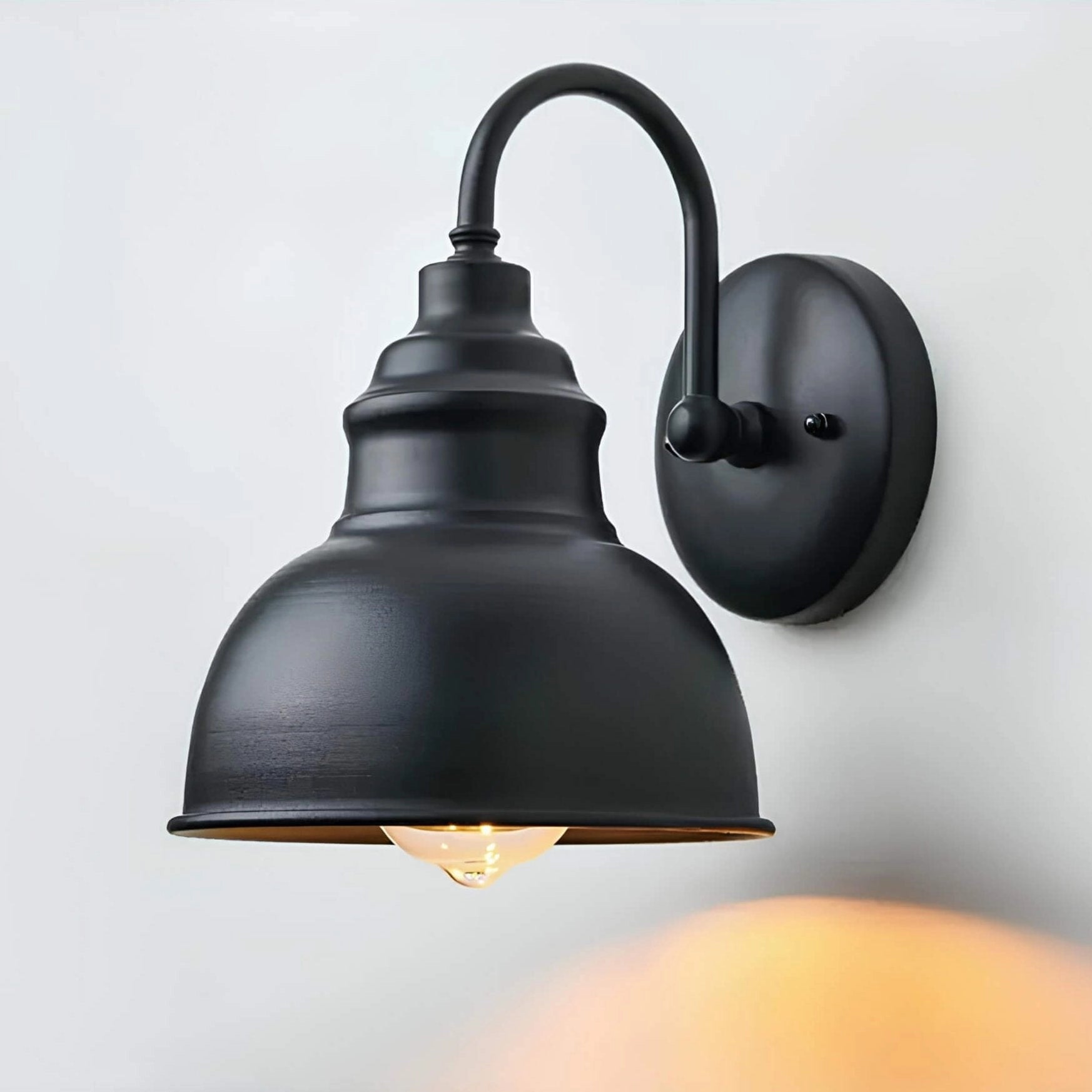 Matte black vintage industrial wall sconce with an Edison bulb, featuring a metal construction and sleek design, mounted on a wooden surface.