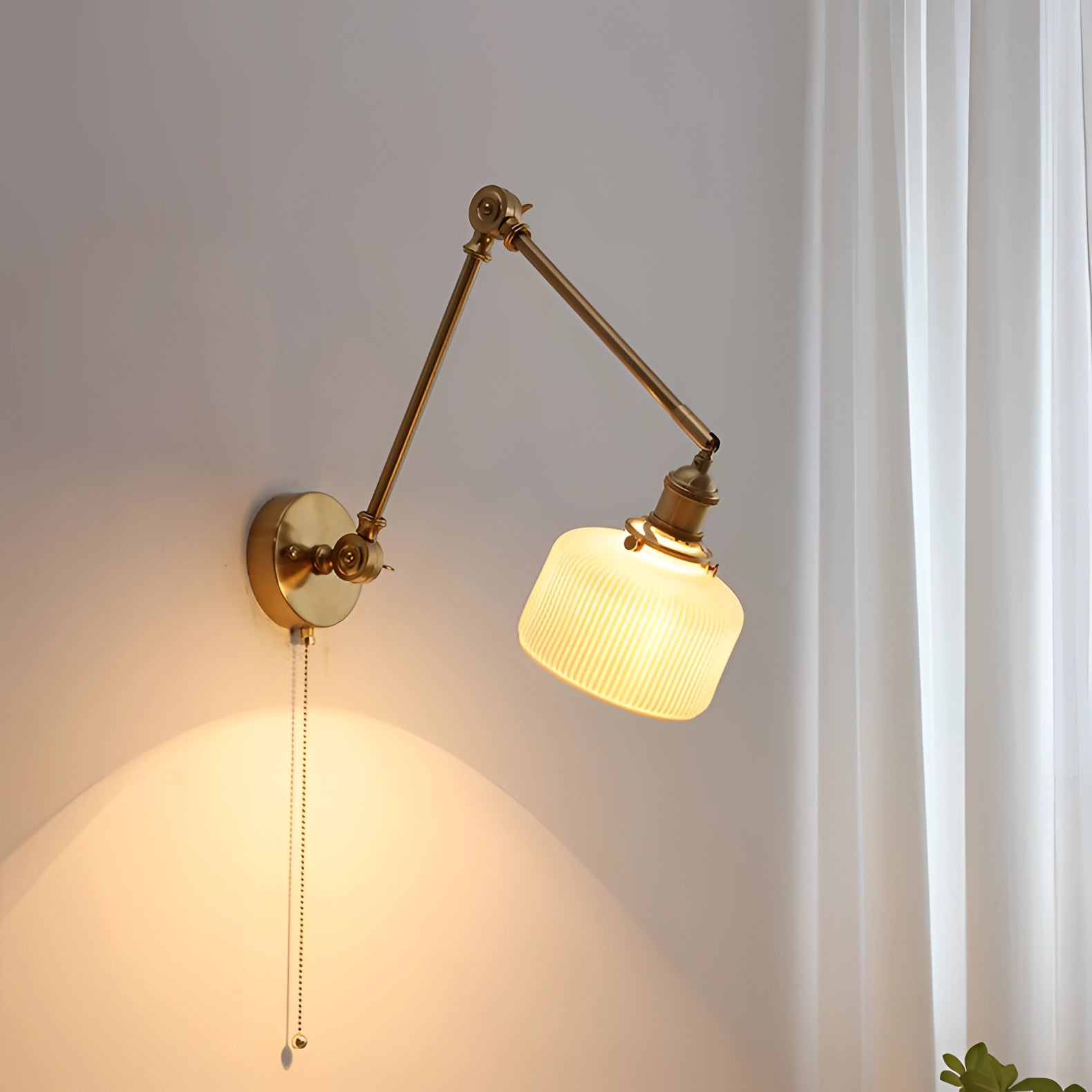 Mid-Century Adjustable Brass Wall Sconce with Cylinder Shade, featuring a vintage design. The lamp is mounted on a wooden wall panel and emits a soft glow, highlighting its brass finish.