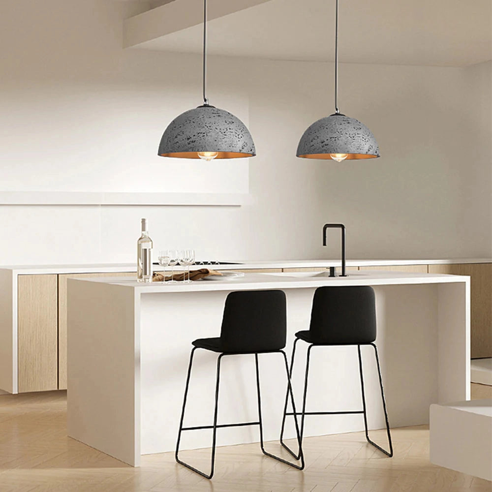 Mid-century minimalist LED pendant light with a speckled grey shade, hanging above a modern interior setting featuring a wooden table, chairs, and shelving.