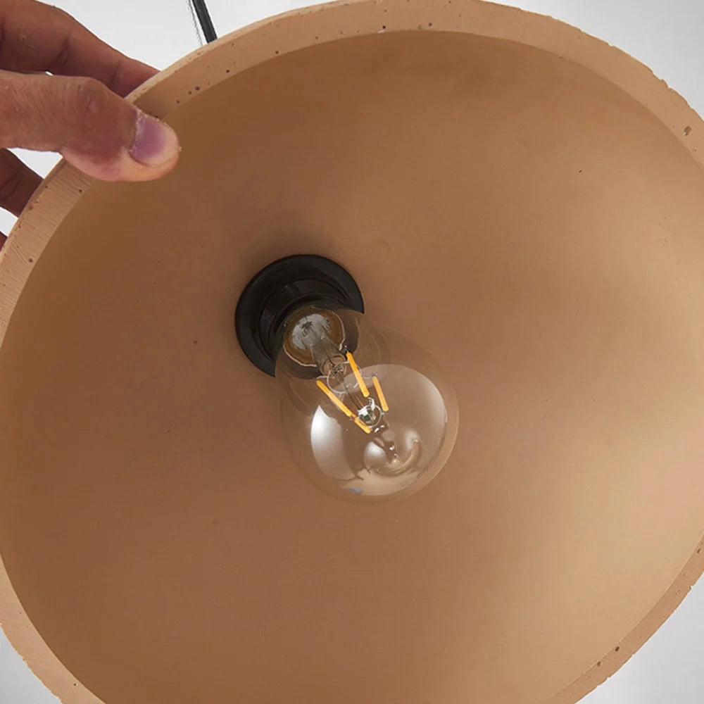 Mid-century minimalist LED pendant light with a speckled shade, featuring a combination of metal and wood elements, suspended from the ceiling.
