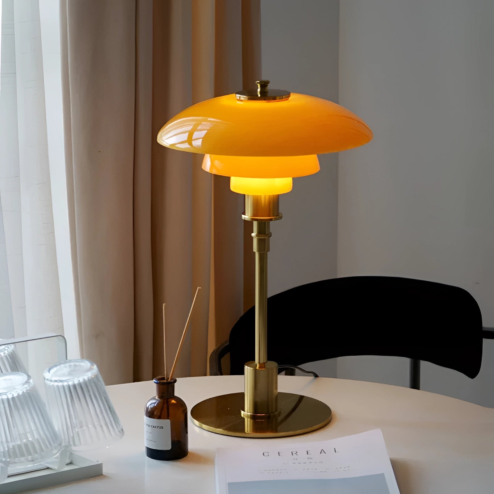 Mid-Century Modern Adjustable Brass Table Lamp with Orange Glass, showcasing Danish design, placed on a wooden table in an interior setting.