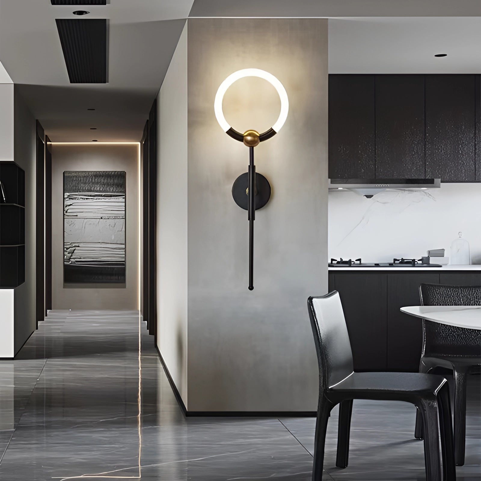 Minimalist black circular LED wall lamp with gold accents, mounted on a wall in a modern interior setting, featuring a black-and-white color scheme.