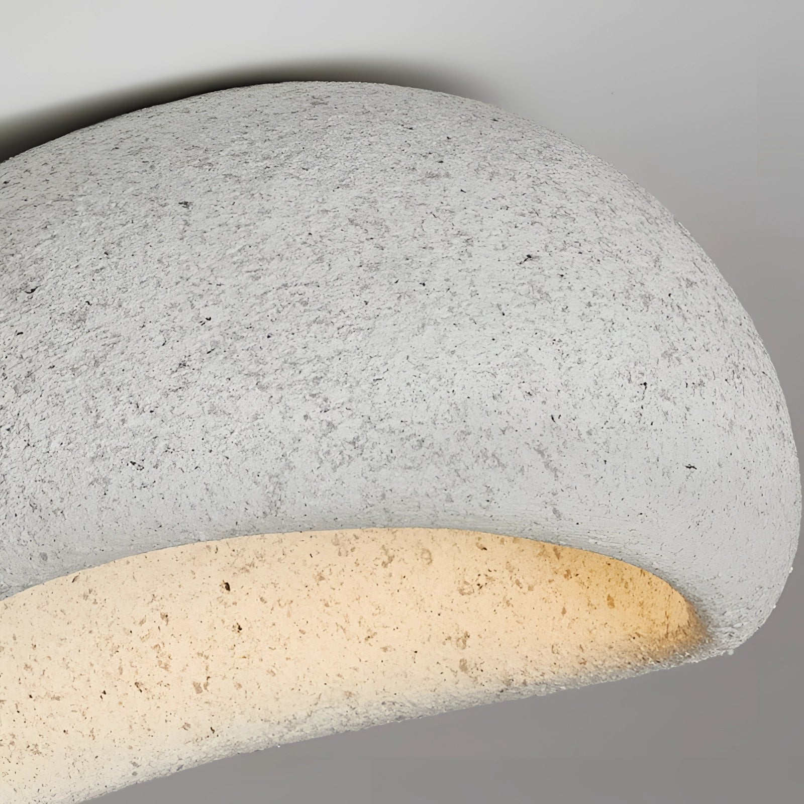 Minimalist half-moon wall sconce with a sleek metal design, mounted on a wooden background, providing ambient interior lighting.