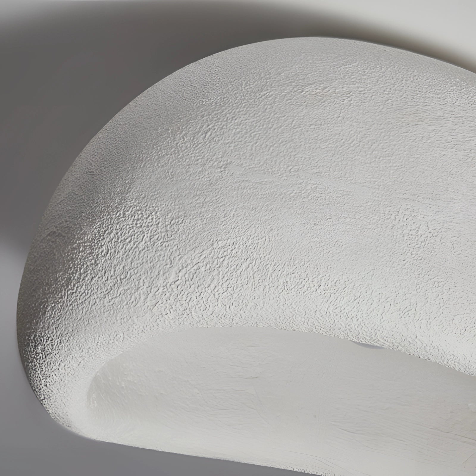 Minimalist half-moon wall sconce in a monochrome grey design, featuring a circular form that enhances ambient interior lighting.