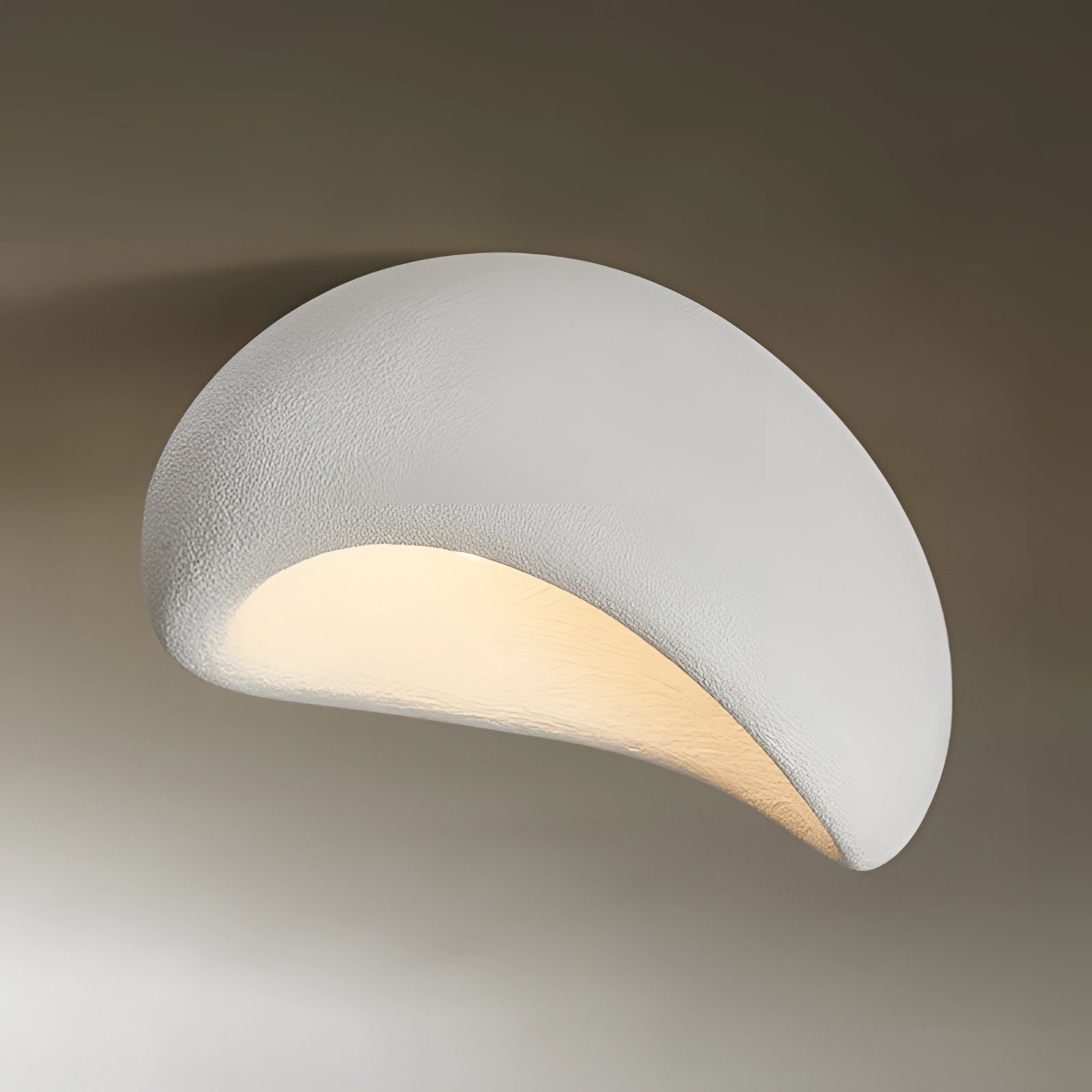 Minimalist half-moon wall sconce in white with a bevel connection, measuring 23.5 inches; designed for ambient interior lighting with a sleek, circular shape and modern aesthetic.