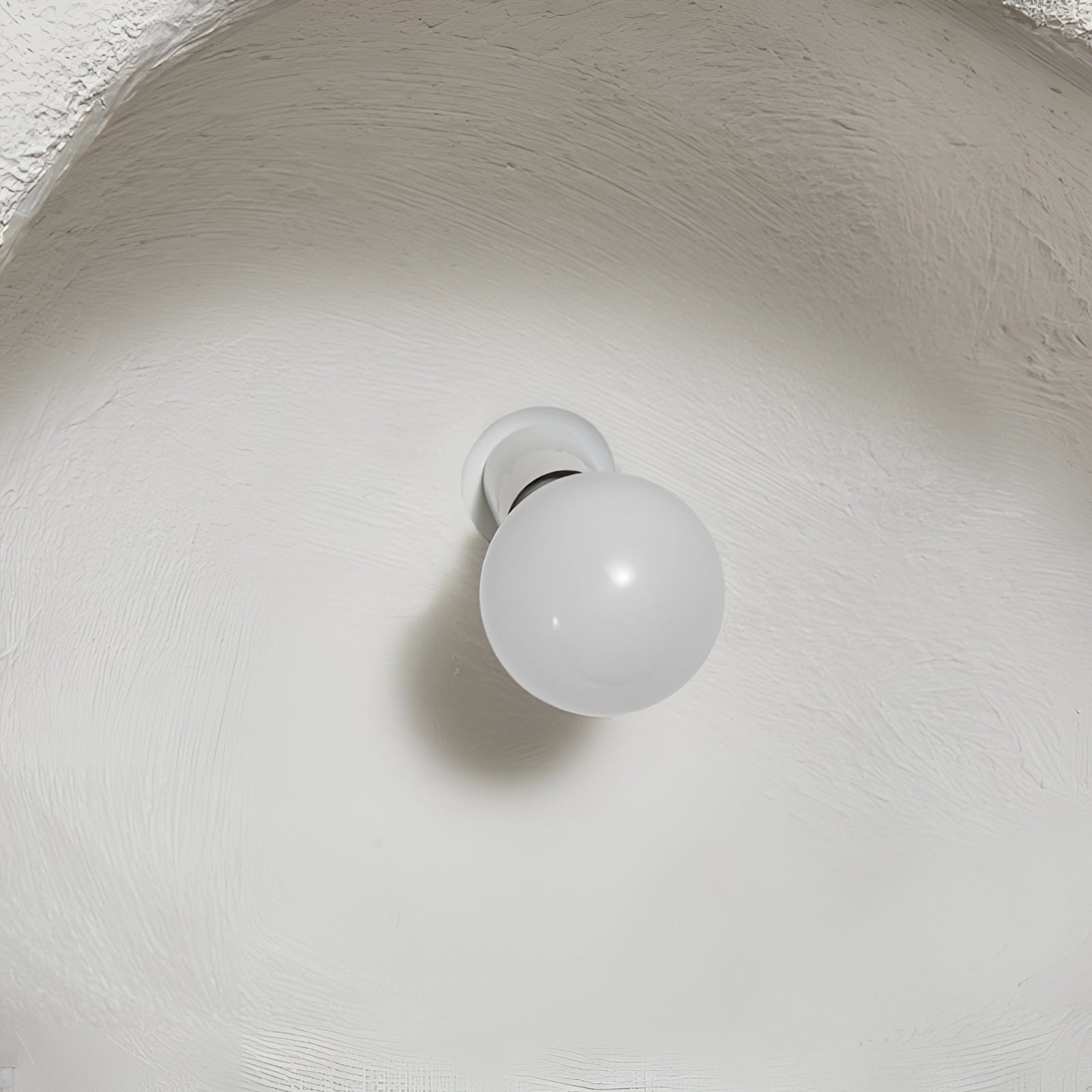 Minimalist Half-Moon Wall Sconce featuring a sleek metal design, mounted on a wall to provide ambient interior lighting.