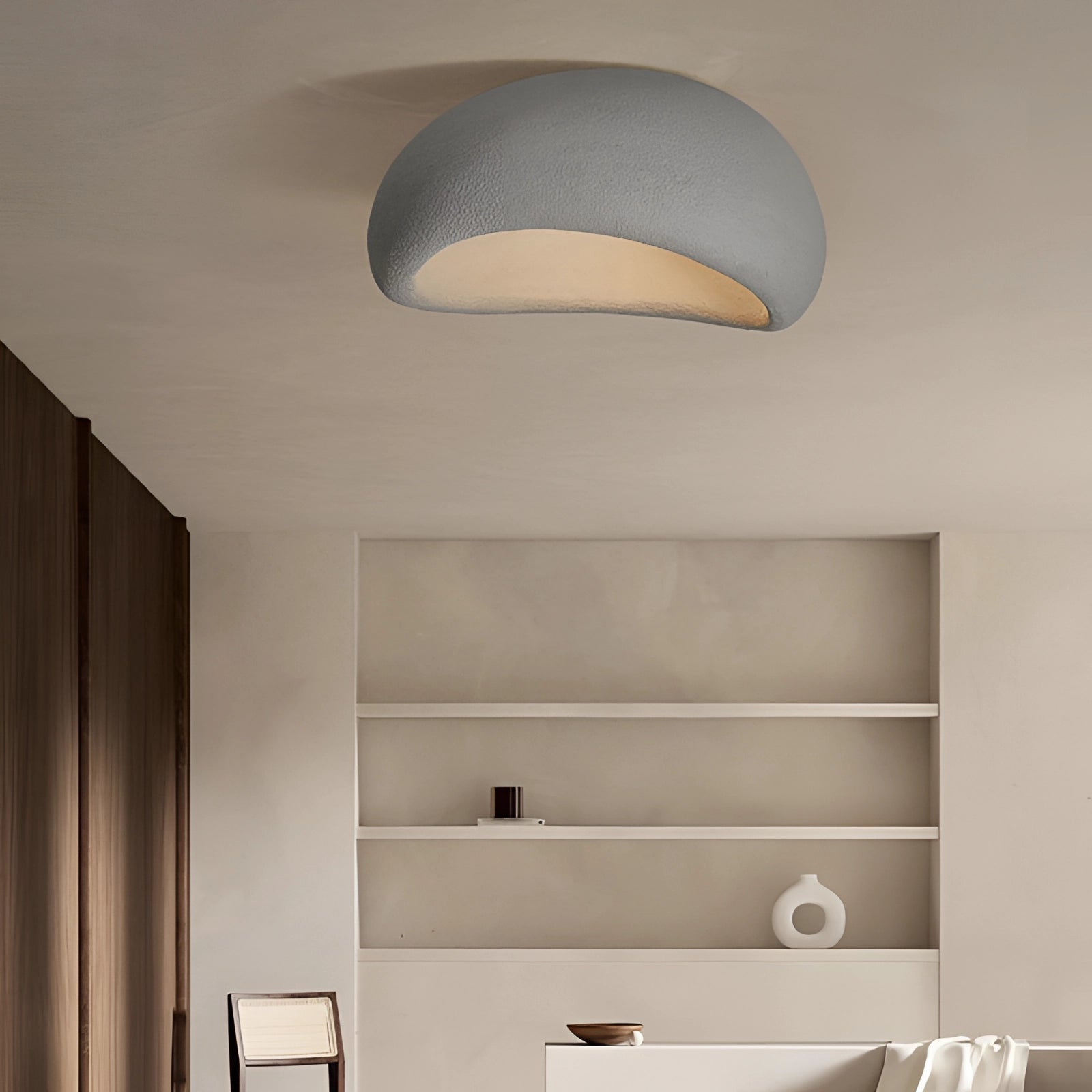 Minimalist half-moon wall sconce in gray, measuring 23.5 inches, mounted on a wall in an interior setting, featuring a sleek and modern design that complements the surrounding decor and furniture.