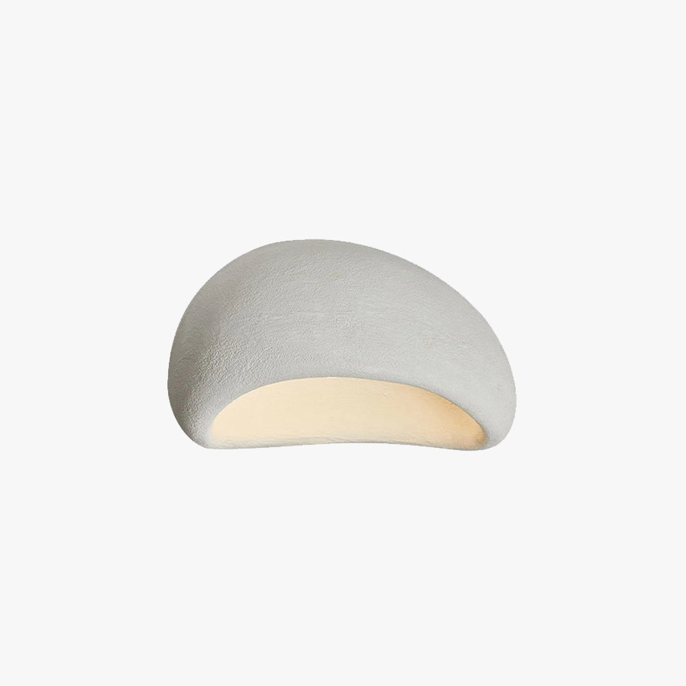 Minimalist half-moon wall sconce with a beige finish, featuring a circular design and metallic elements, mounted on an interior wall to provide ambient lighting.