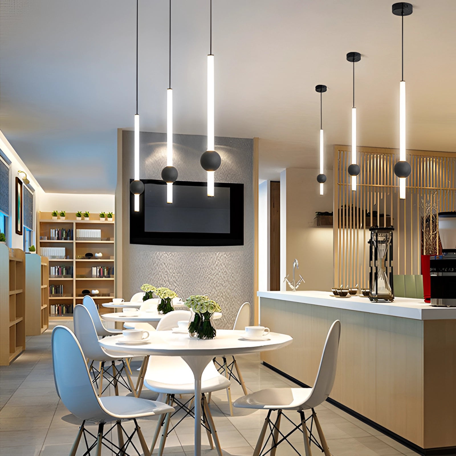 Minimalist LED pendant light featuring a black and white cylindrical globe hanging above a wooden table in a modern interior setting, with surrounding furniture like chairs and cabinetry.