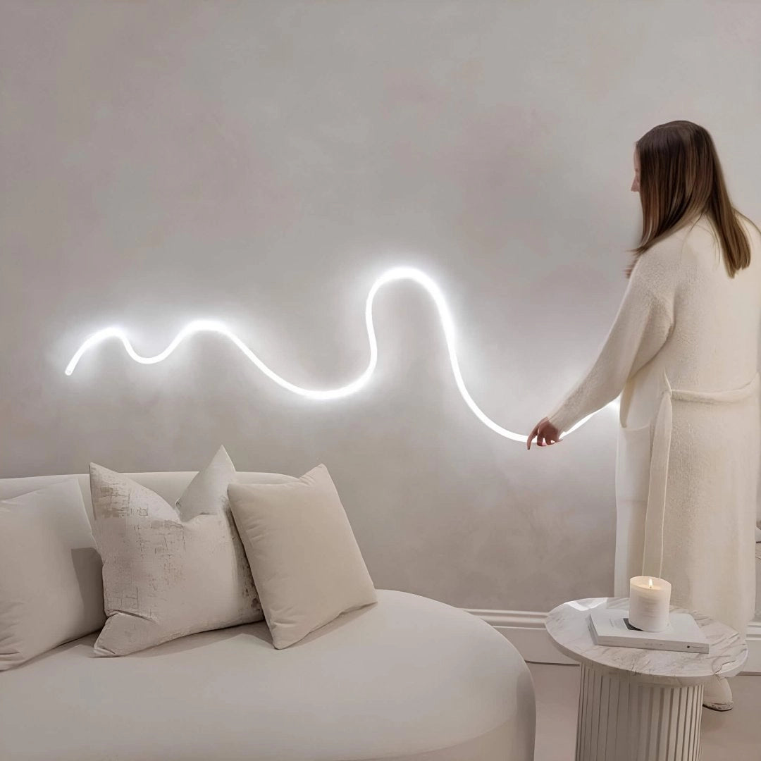 Minimalist LED wall light with a wave pattern design, featuring adjustable brightness, mounted on a grey wall in a modern interior setting.