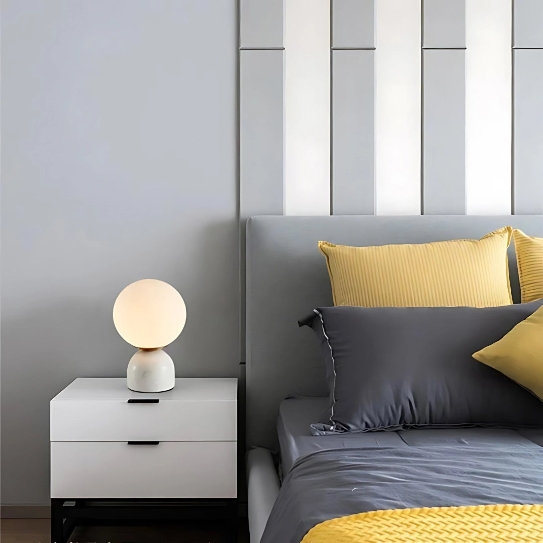White minimalist marble table lamp with a modern orb globe design, set on a rectangular wooden base, ideal for Scandinavian decor and interior design.