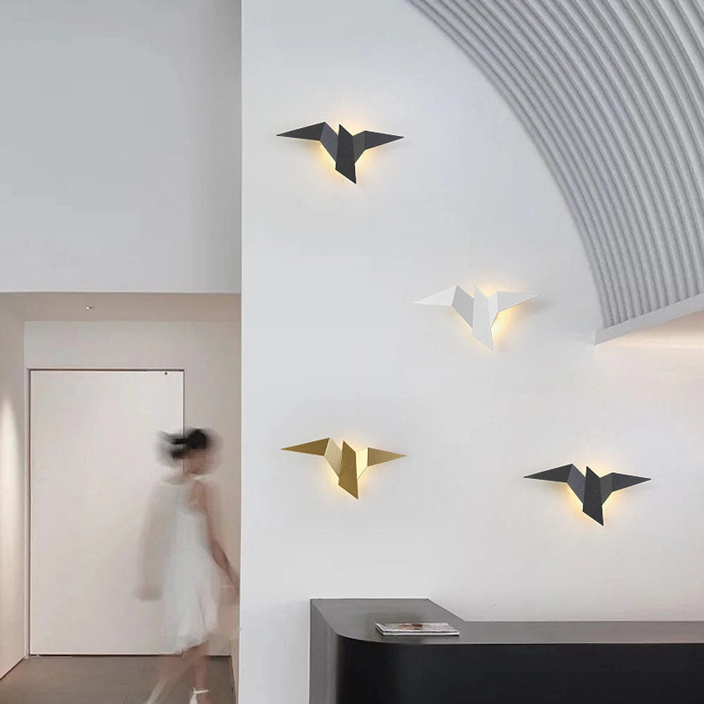 Minimalist origami bird-shaped LED wall lamp with a geometric modern design, featuring a wooden base and illuminated wings.