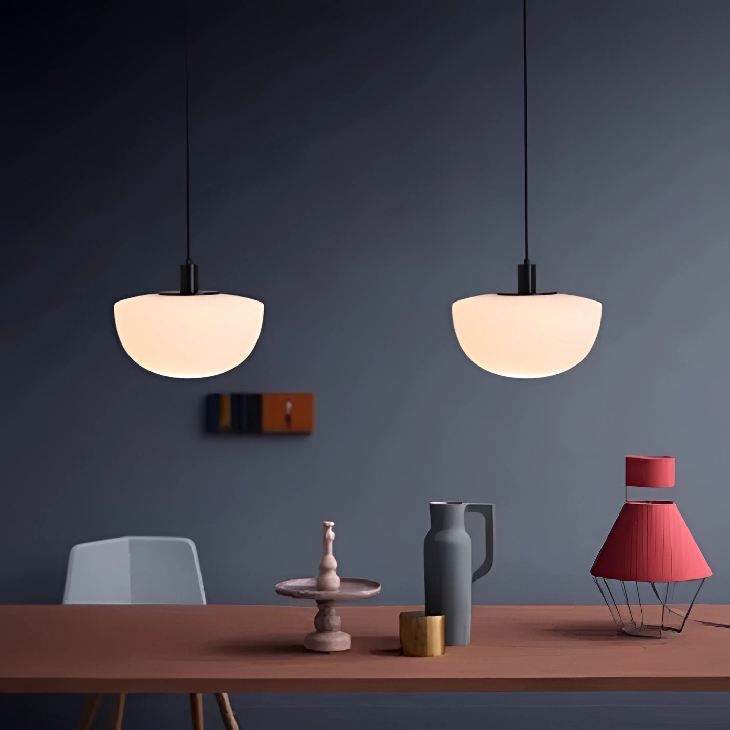 Minimalist pendant light featuring a modern Scandinavian design, hanging above a wooden dining table in a contemporary interior setting with grey accents.