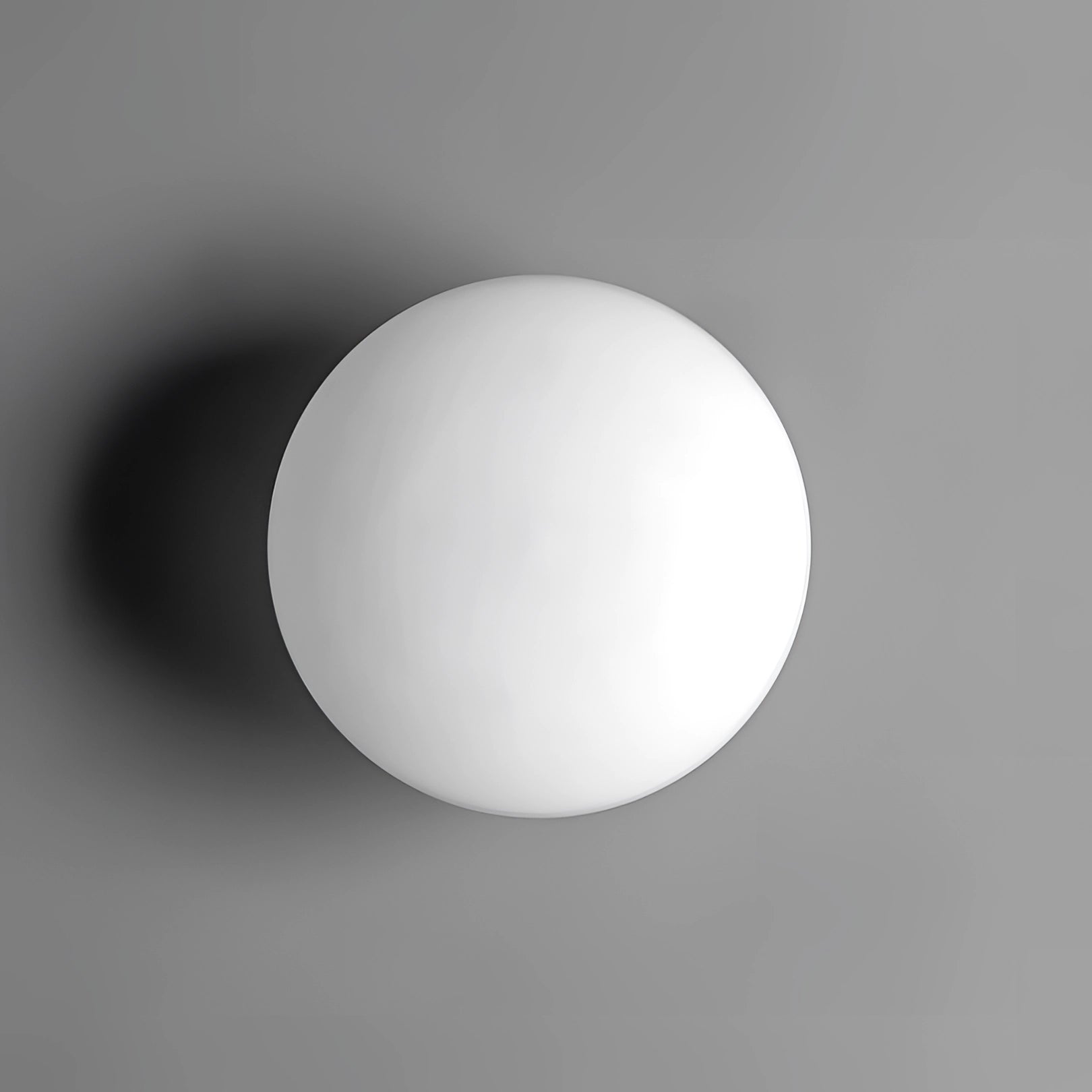 Minimalist round LED wall light, 8 inch, emitting a soft monochrome glow, mounted on a contemporary bathroom wall against a dark background.