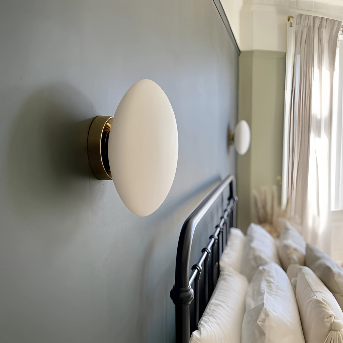 Minimalist round LED wall light mounted on a beige wall in a contemporary bathroom setting, highlighting its sleek design and soft illumination amidst neutral tones.