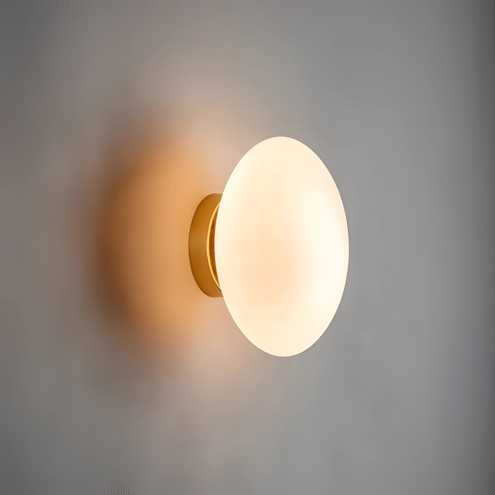 Minimalist round LED wall light fixture mounted on a wooden wall, featuring a sleek circular design that emits a soft glow, suitable for contemporary bathroom settings.