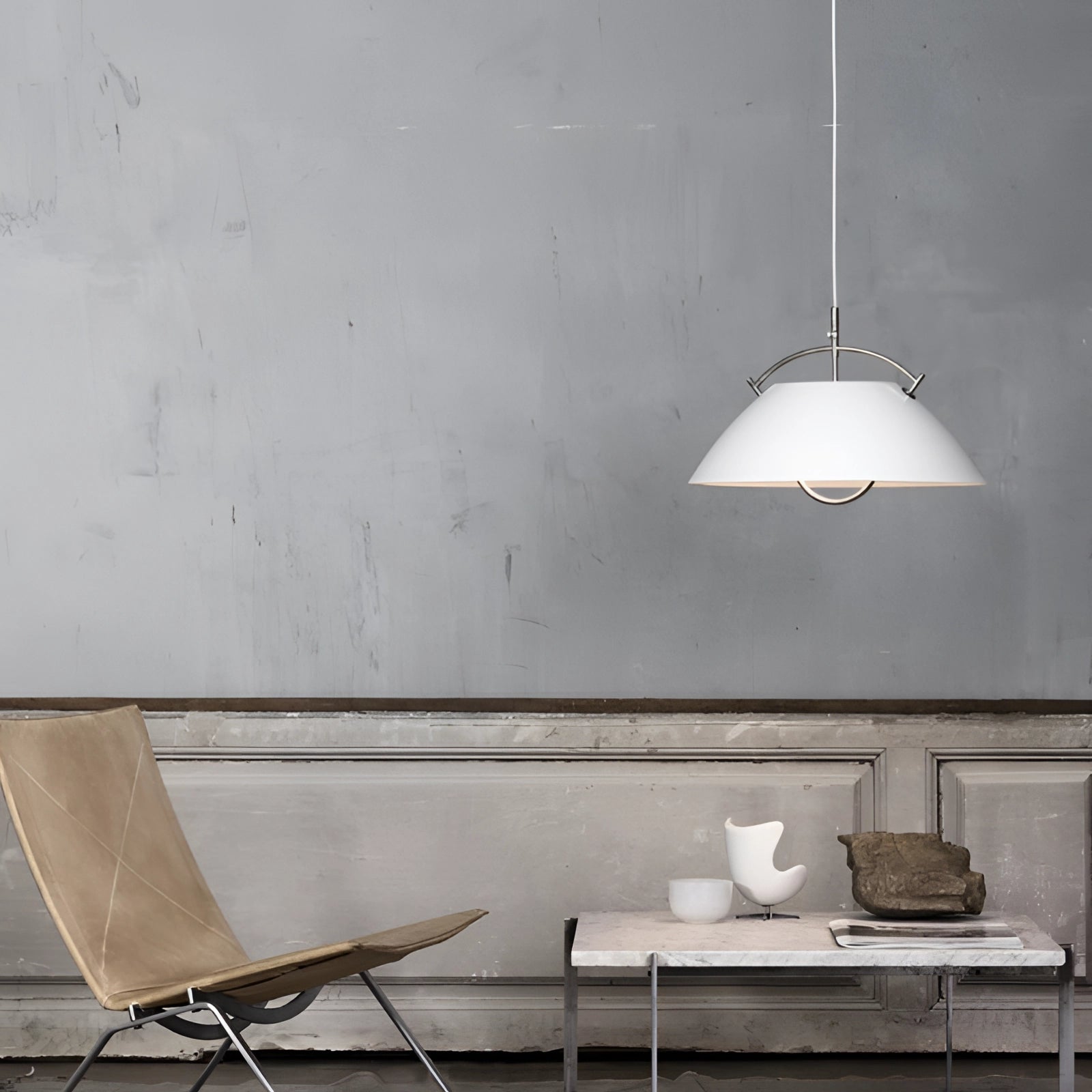 Minimalist Scandinavian white pendant light with a modern adjustable design, featuring a sleek white shade. The light is displayed in an interior setting with a wooden table and grey chairs, emphasizing its elegant and contemporary aesthetic.