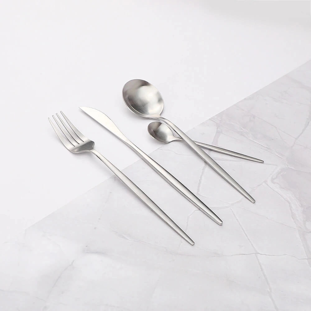 Minimalist stainless steel cutlery set displayed on a rectangular table setting, featuring a sleek and elegant design, with metal utensils arranged artistically on linen placemats, suitable for formal dining events.