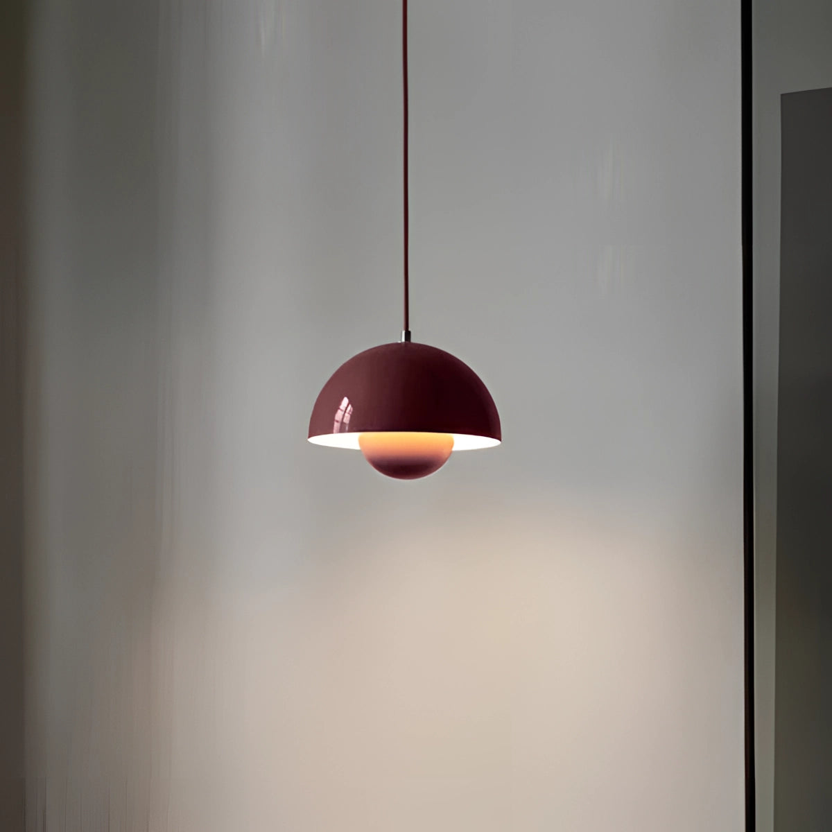 Minimalist white dome pendant light with a burgundy shade, featuring a Scandinavian design, ideal for dining and kitchen areas. The light has a sleek round lampshade and a wooden element, designed to hang from the ceiling as a modern fixture.