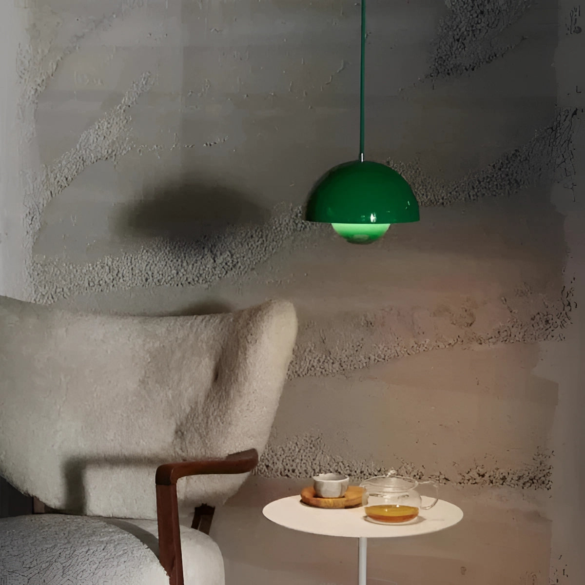 Minimalist white dome pendant light with a green accent, hanging above a Scandinavian-style dining and kitchen area, featuring a wooden table and chairs, creating a cozy and artistic atmosphere.