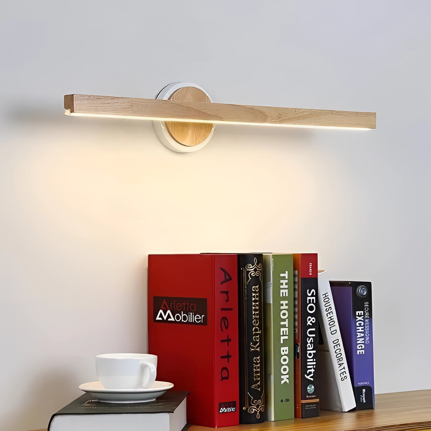 Minimalist Wooden LED Wall-Mounted Light Bar with Adjustable Brightness mounted above a wooden shelf holding books, tableware, and decorative items.