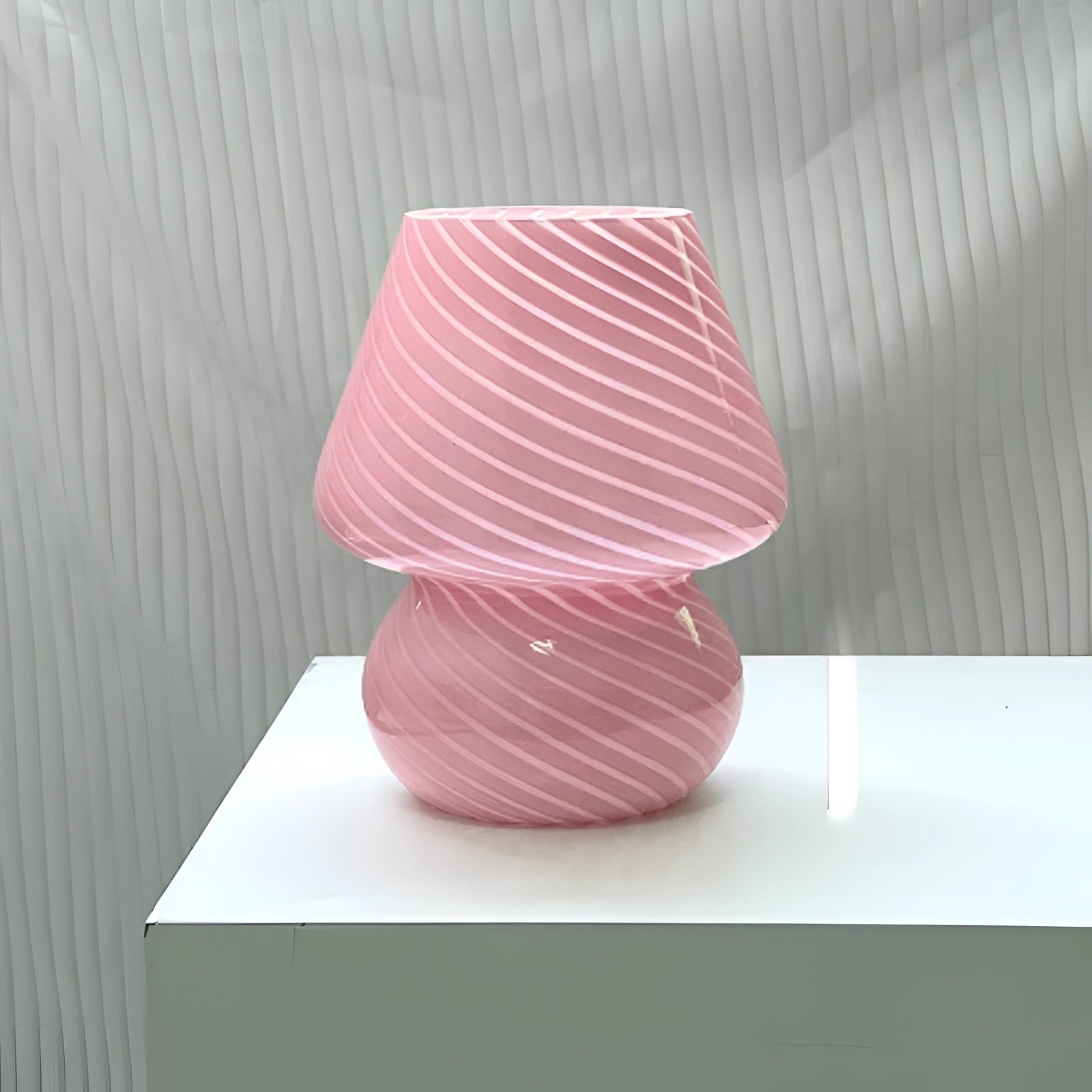 Modern 3D printed table lamp featuring a pink swirl design with LED lighting, showcasing an abstract, artistic shape reminiscent of a vase. The lamp is set on a wooden surface, highlighting its contemporary design in shades of purple and magenta.