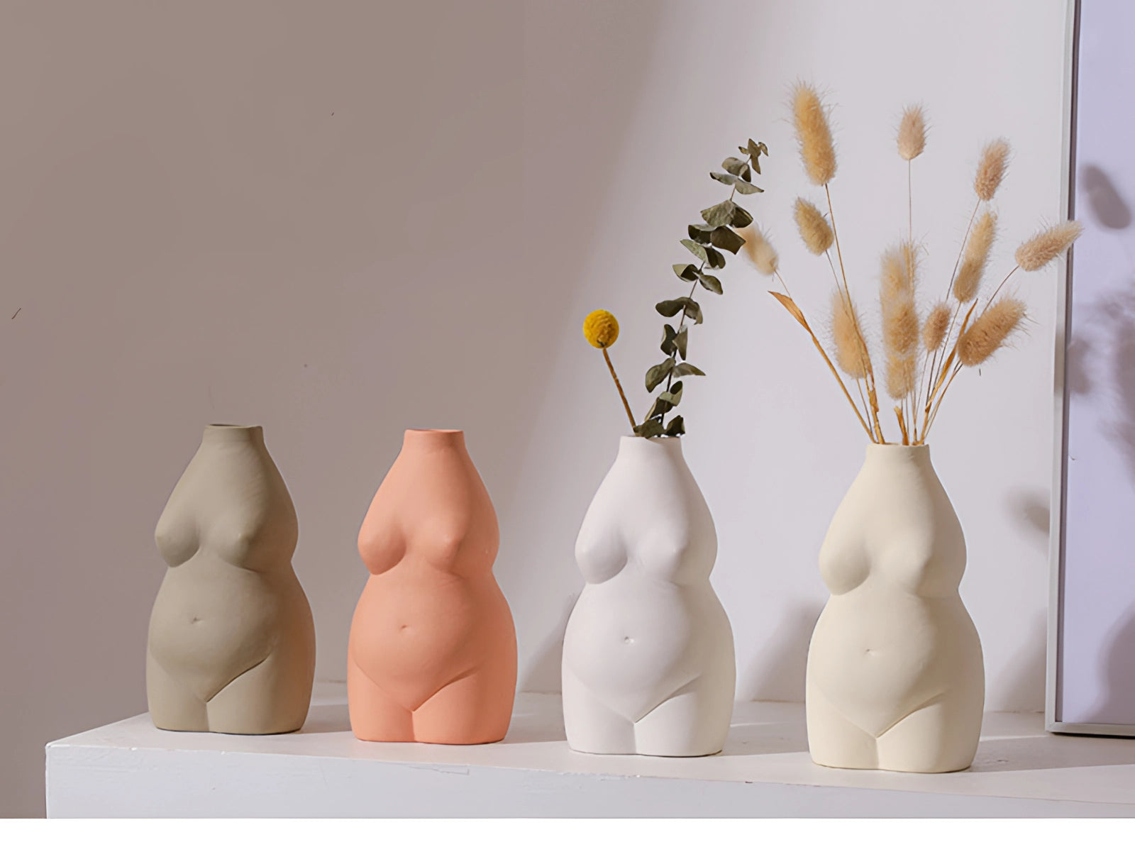 Modern abstract female form vase with an Art Deco body-shaped design, featuring a smooth pottery finish. The vase is crafted to resemble a stylized human form, providing a unique and artistic way to display plants or decorative twigs. The image showcases the vase's artistic qualities and creativity in design, making it a statement piece for any interior space.