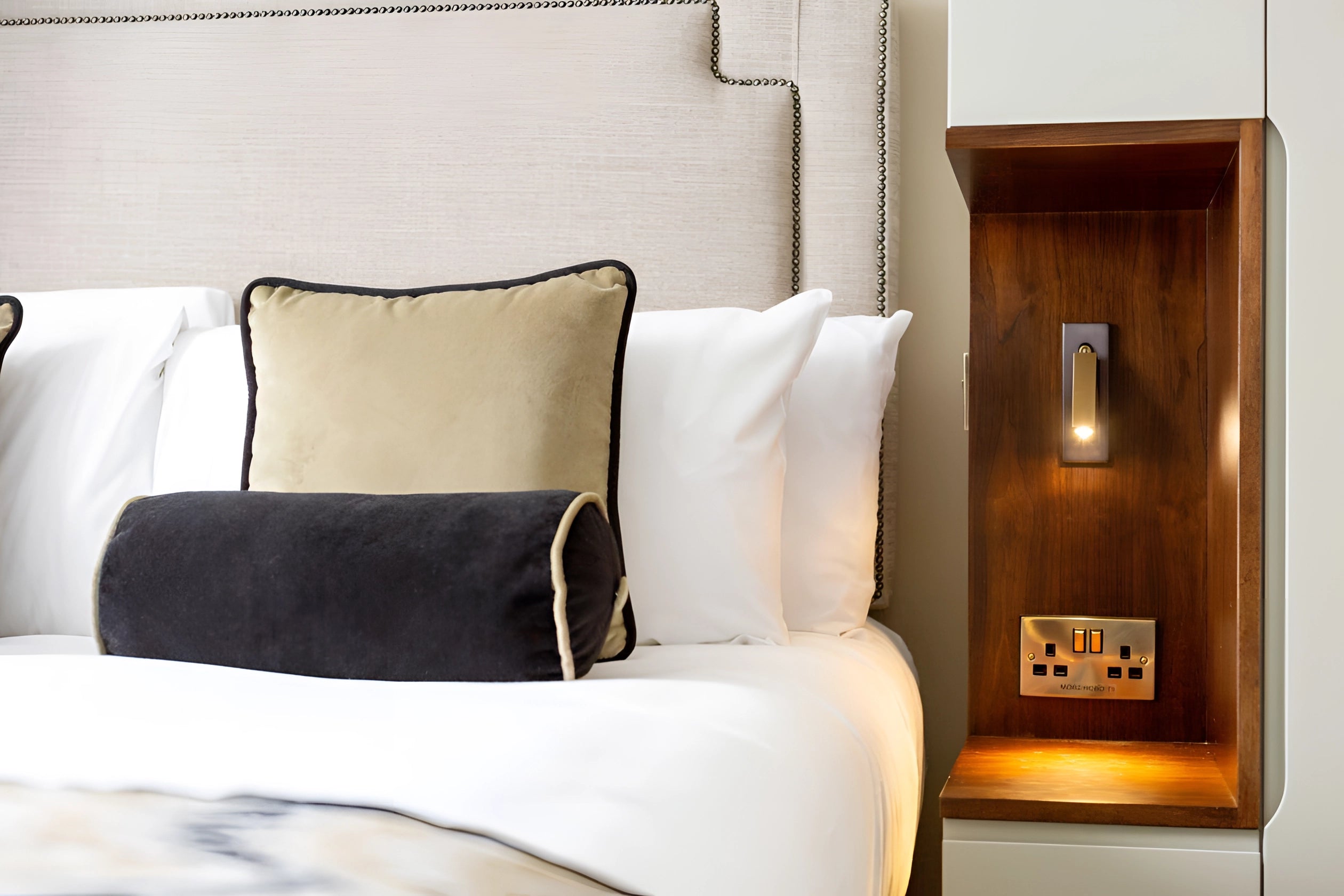 Modern black adjustable LED wall light with weather-resistant finish and motion sensor, mounted on a wall in a contemporary interior setting.