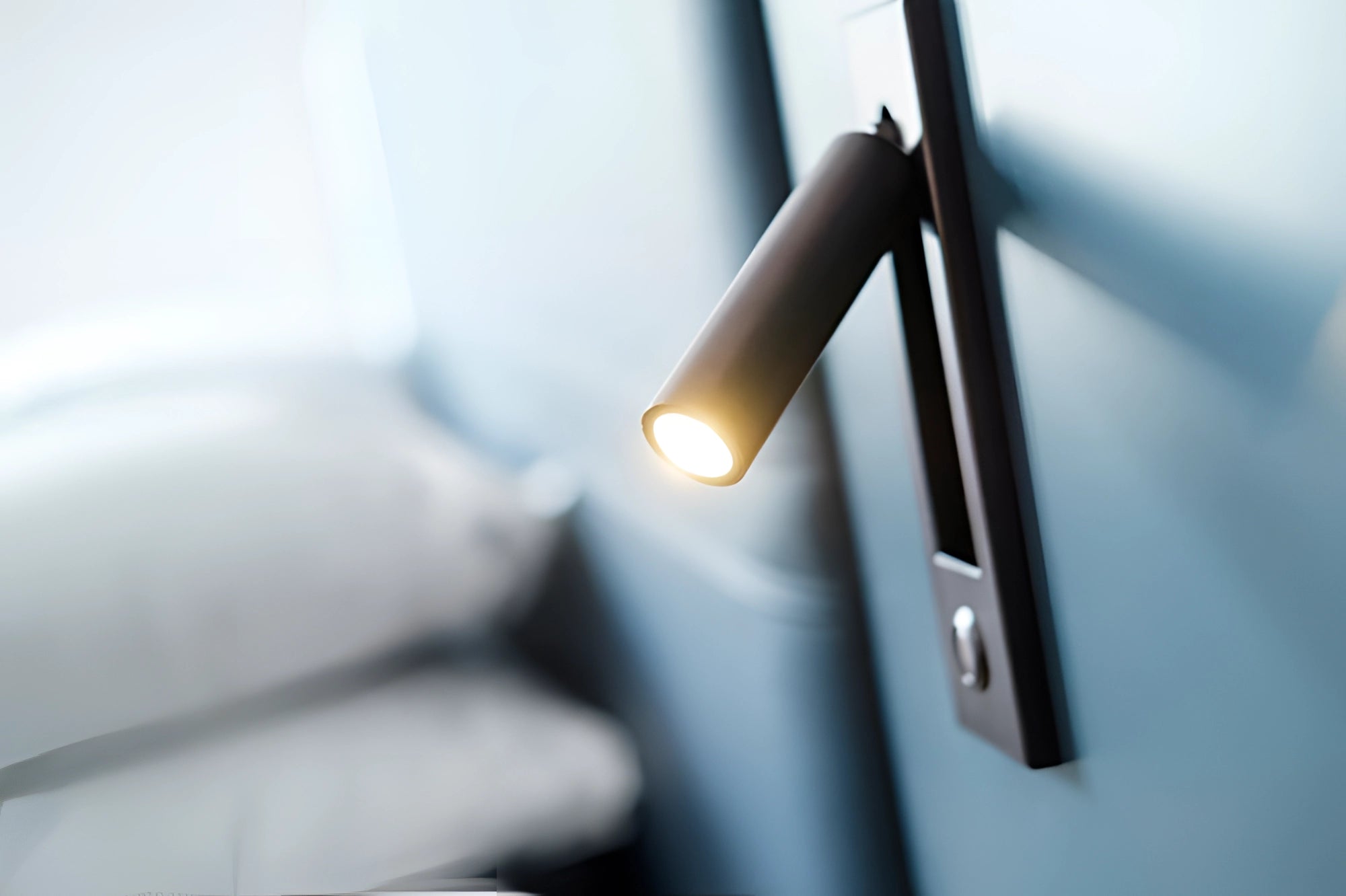 Modern black weather-resistant LED wall light with motion sensor, mounted on exterior wall demonstrating sleek design and durability.