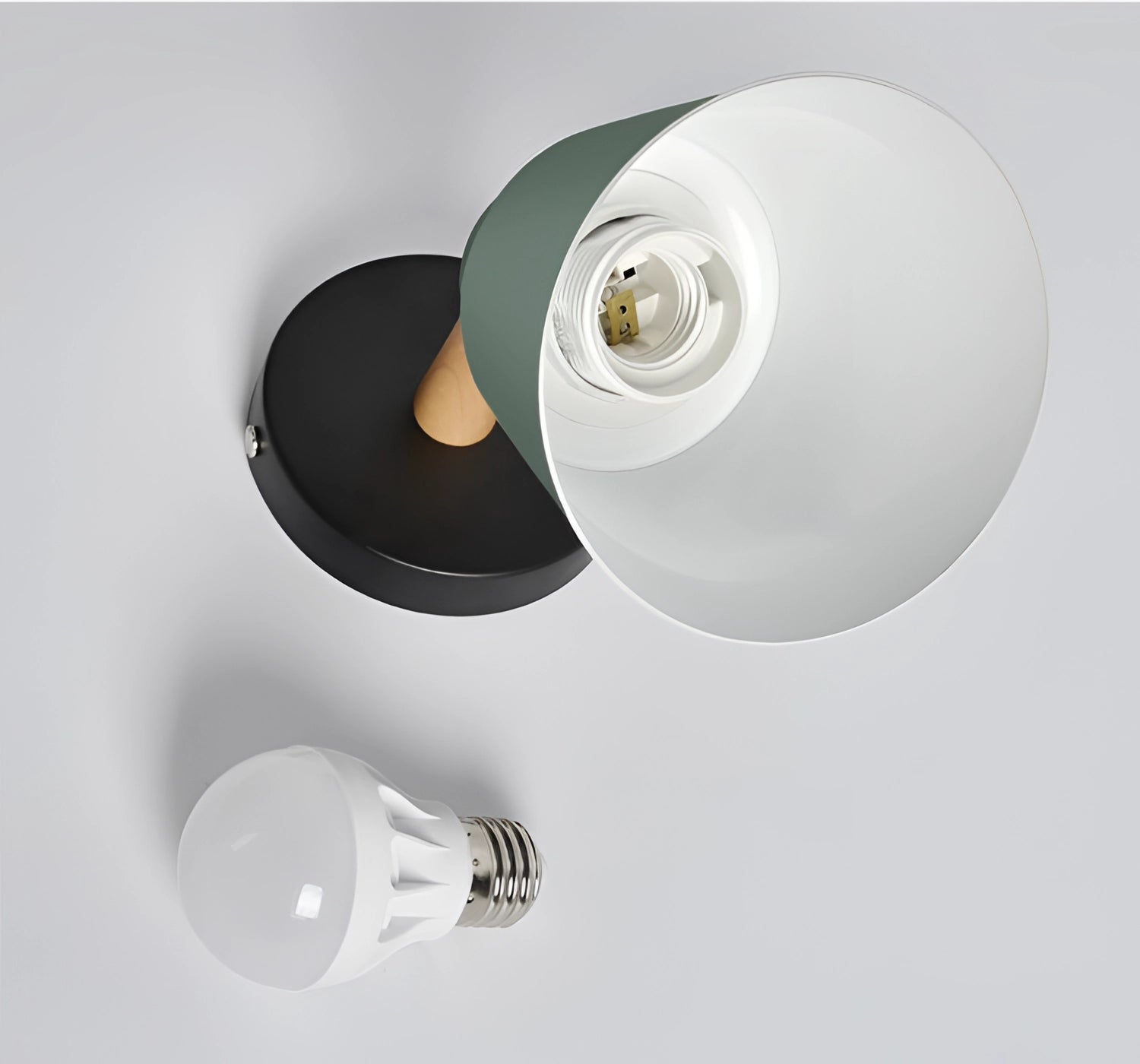 Modern adjustable matte grey sconce with wooden pivot, featuring a cylindrical design, mounted on the ceiling in a bedroom setting.