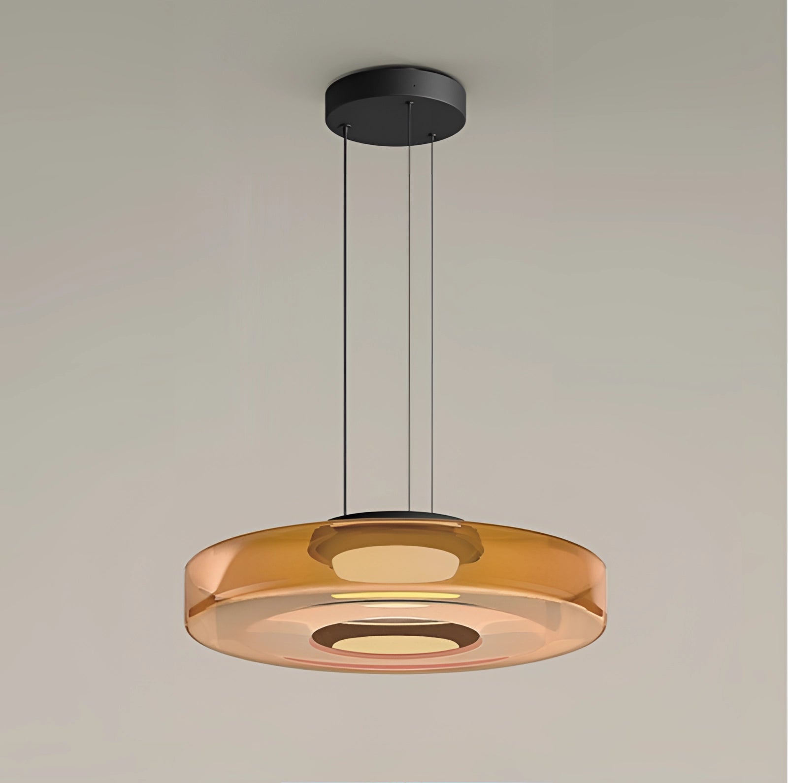 Modern amber glass pendant light with a luxury, minimalist, tiered design; features a circular shape and metal accents, suitable for ceiling installation.