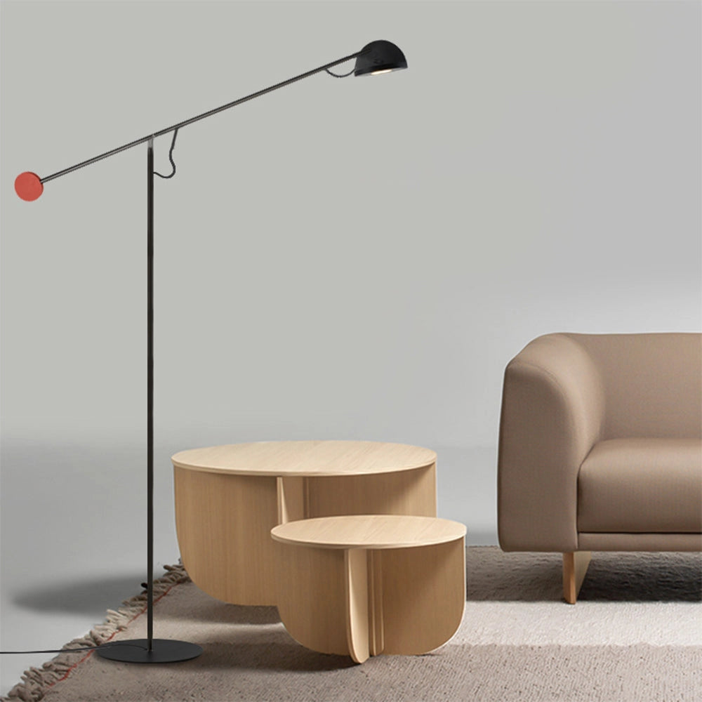 Modern arc floor lamp in sleek black finish with an adjustable design, situated in an interior space with hardwood flooring and contemporary furniture.