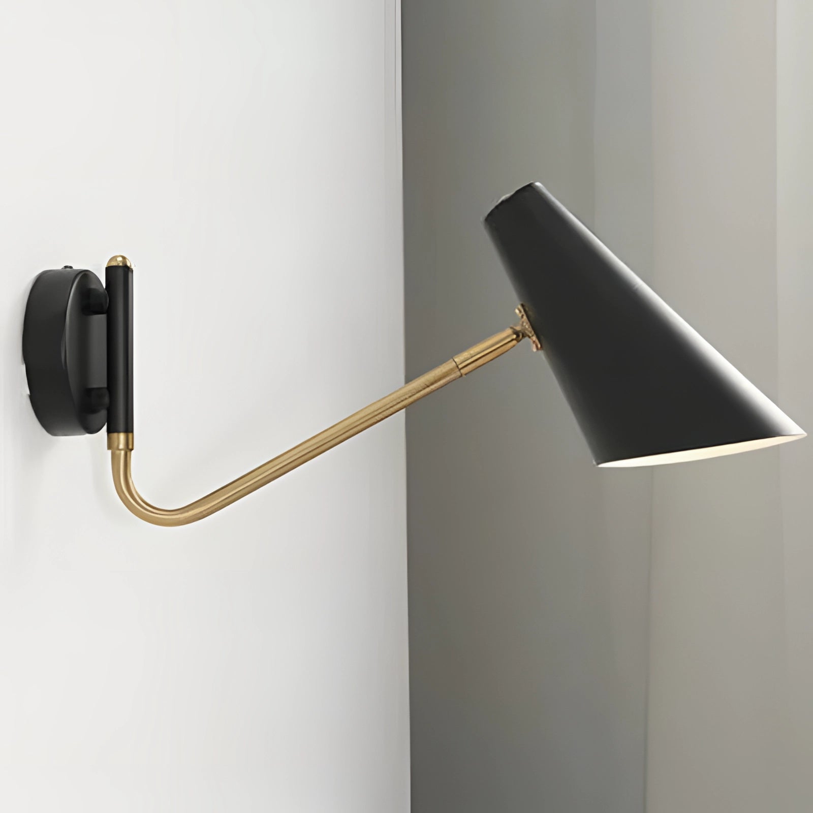 Modern black and gold adjustable wall sconce with a minimalist industrial design, featuring a rectangular metal fixture and a sleek, contemporary style.