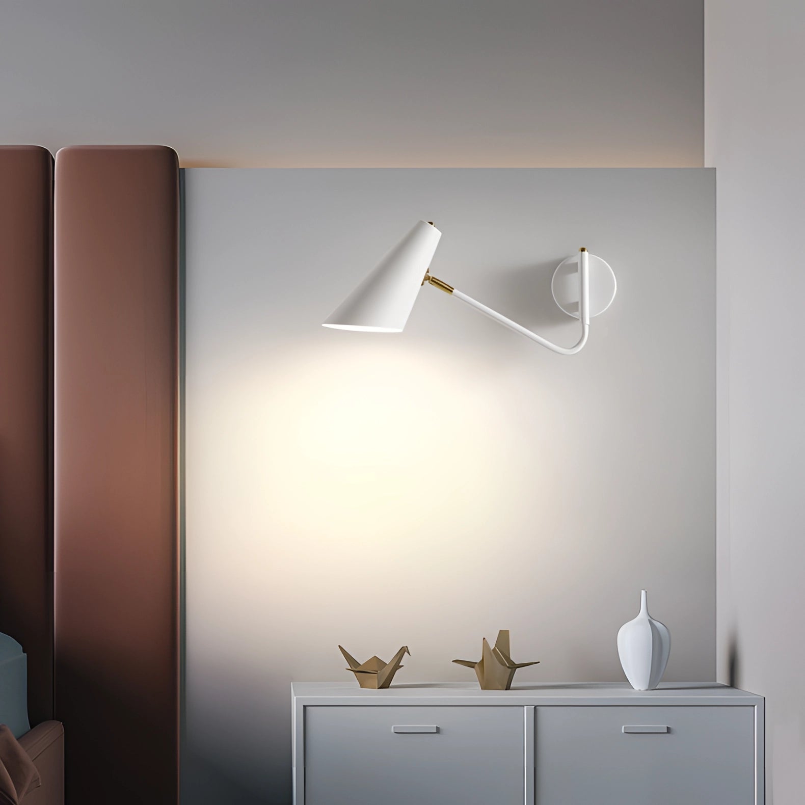 Modern black adjustable wall sconce mounted on a white wall above wooden shelving, showcasing minimalist industrial design in a contemporary interior setting.