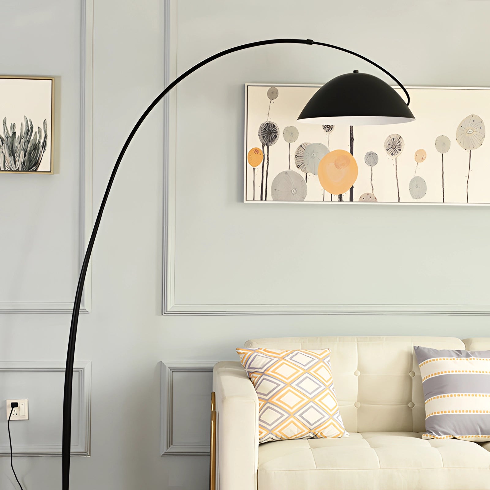 A modern black arched floor lamp with an adjustable dome reading light positioned in a stylishly furnished living room, featuring a cozy couch with pillows, wooden flooring, and a simple architectural design.