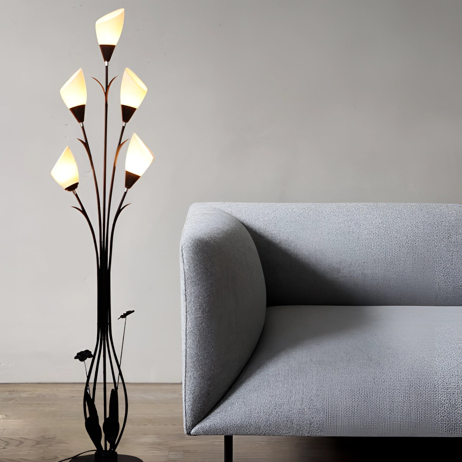 Modern black floral floor lamp with an elegant design, featuring a rectangular wooden base, positioned next to a comfortable couch in a stylish room setting.
