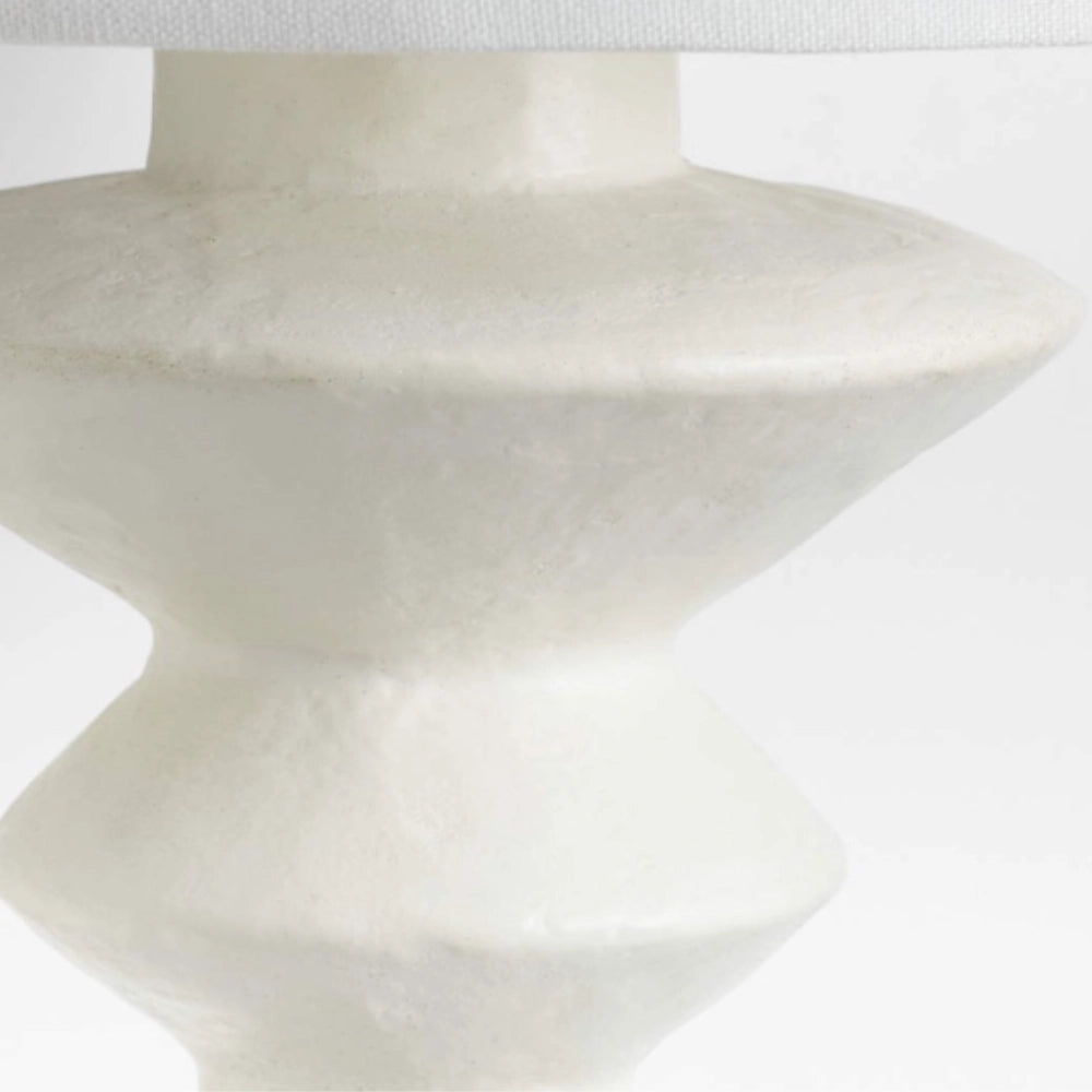 Modern black geometric table lamp with a white shade, featuring a sleek and artistic design.