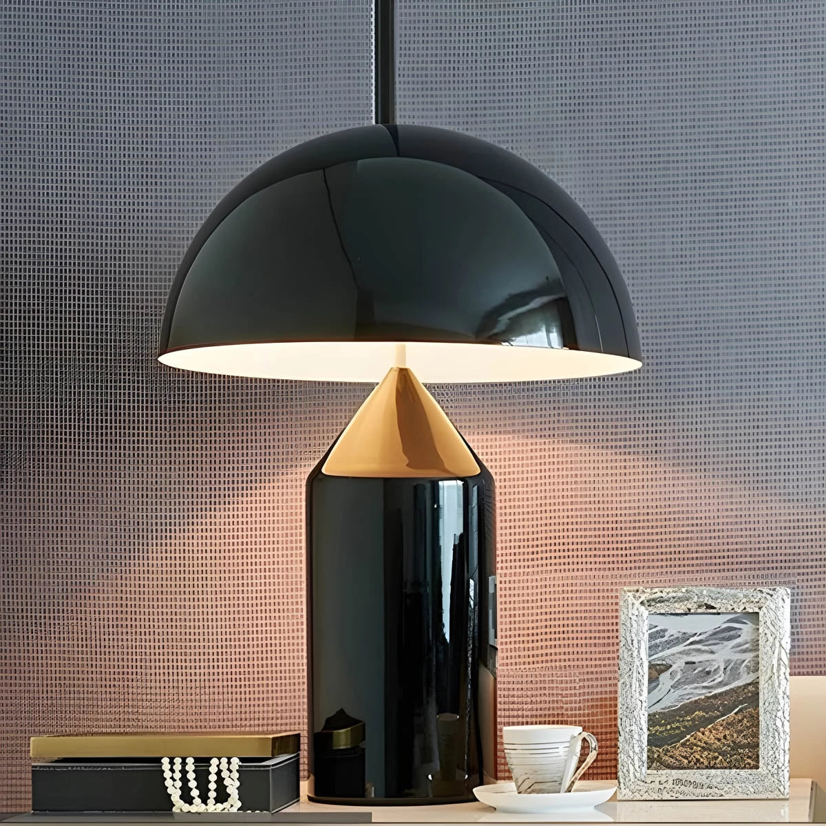 Sleek modern black and gold dome pendant light with geometric design, hanging from the ceiling, illuminating a contemporary interior space.