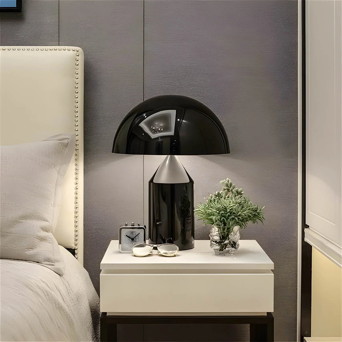 Modern black and gold geometric dome pendant light hanging above a wooden table with a potted houseplant, showcasing luxury interior design.
