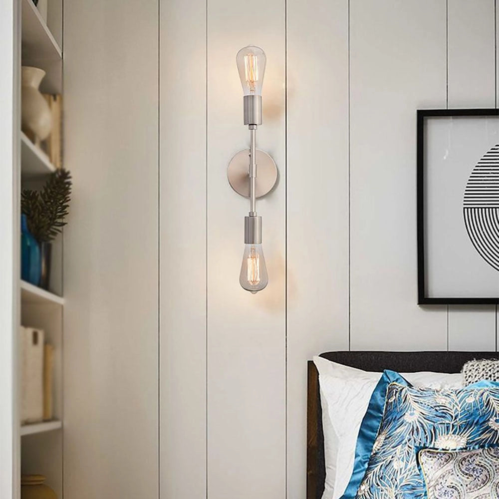 Modern black and gold minimalist wall sconce with Edison bulb mounted on a blue wall, featuring a sleek silver finish.
