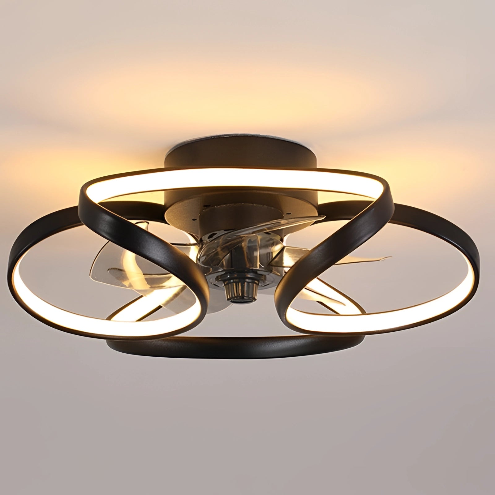 Modern black LED ceiling fan with light and remote installed on a bedroom ceiling.