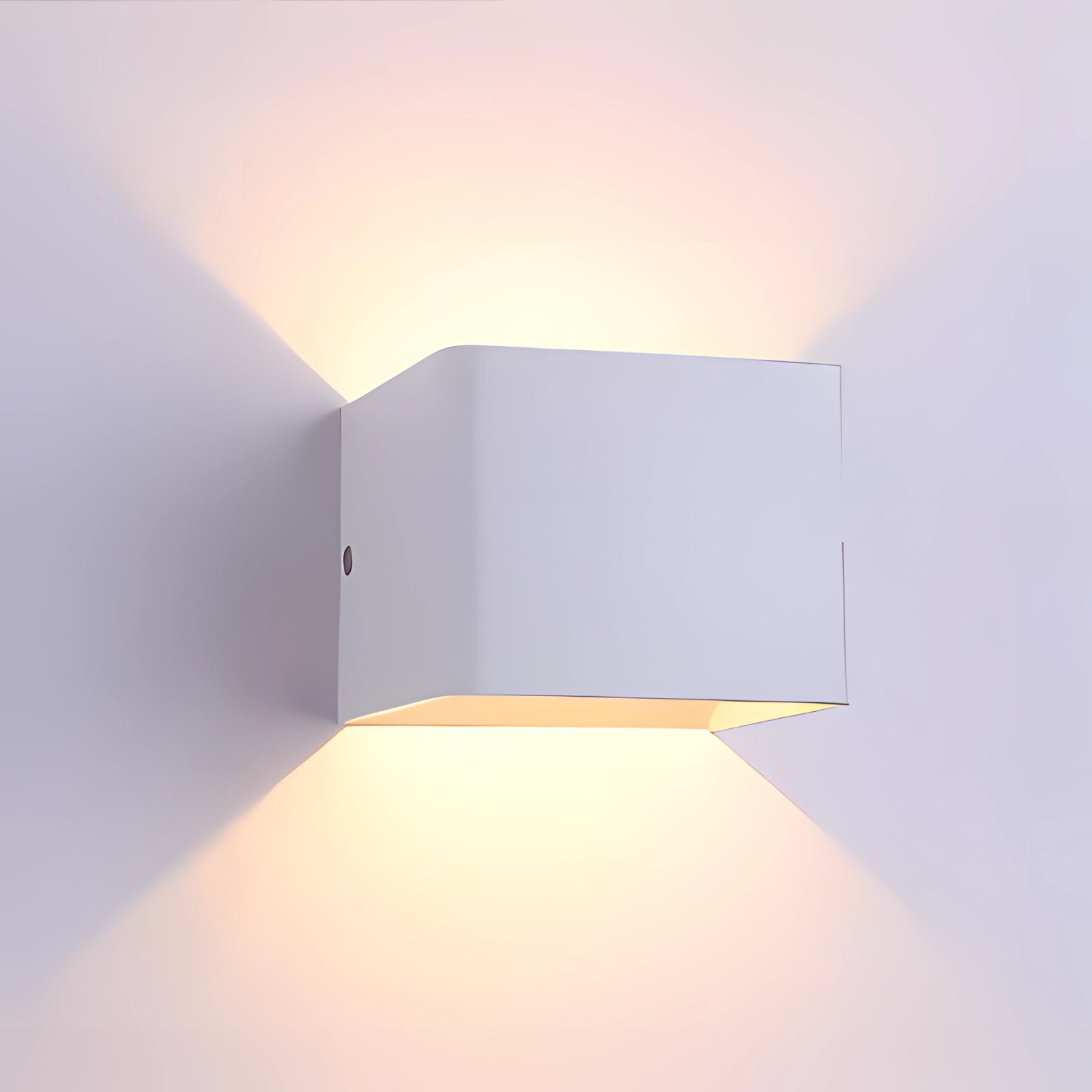 Modern white geometric LED wall sconce mounted on a textured wall, featuring a sleek rectangular design and providing ambient lighting.