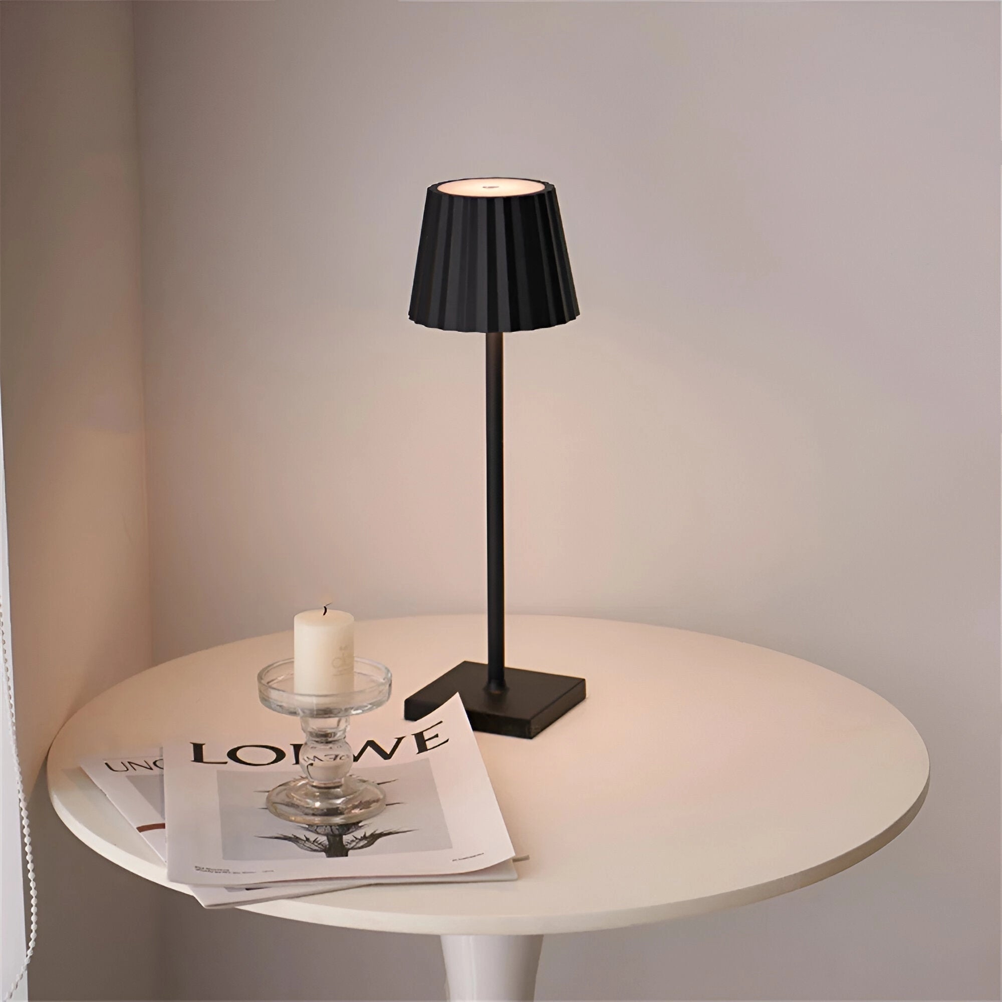 Modern black minimalist LED table lamp with a sleek and elegant design, placed on a wooden table in a well-lit interior setting, showcasing its sophisticated material and minimalist style.