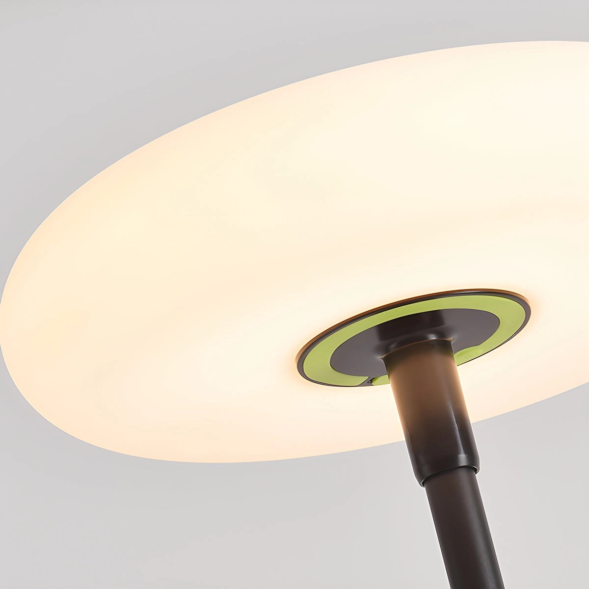 Modern black minimalist LED torchiere floor lamp with a slim design, standing in a room with a wooden floor and circular base.